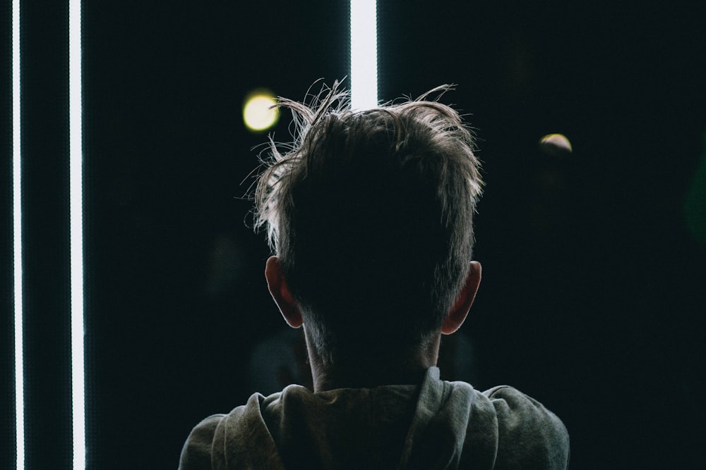 man in gray hoodie looking at the light