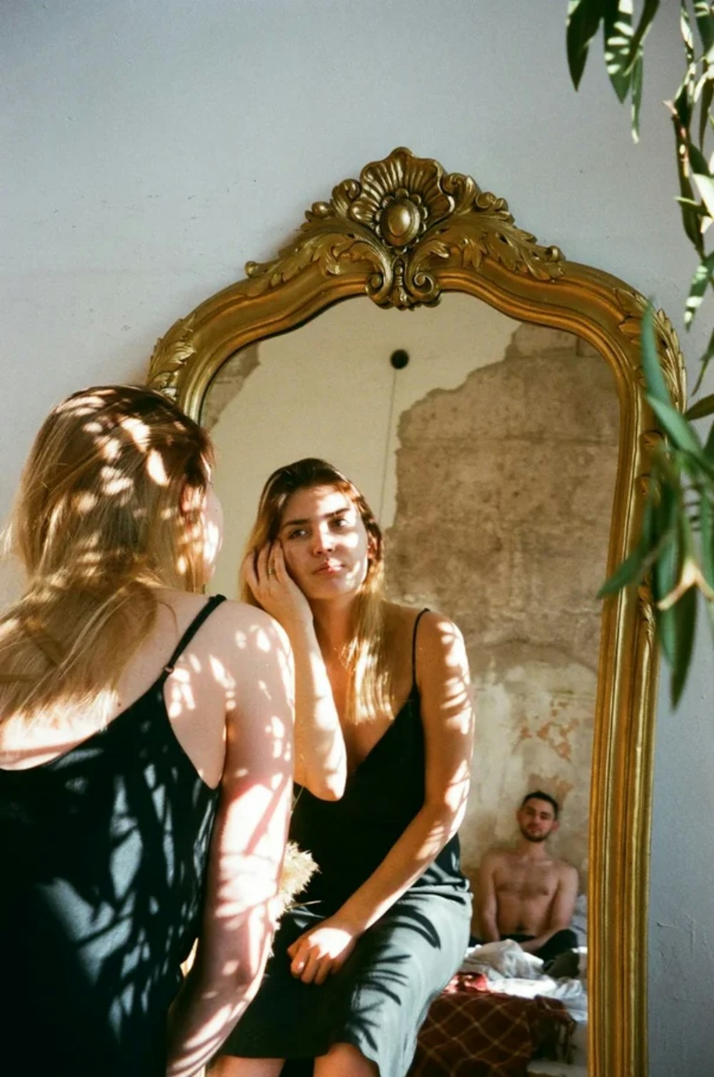 a woman sitting in front of a mirror looking at herself in the mirror