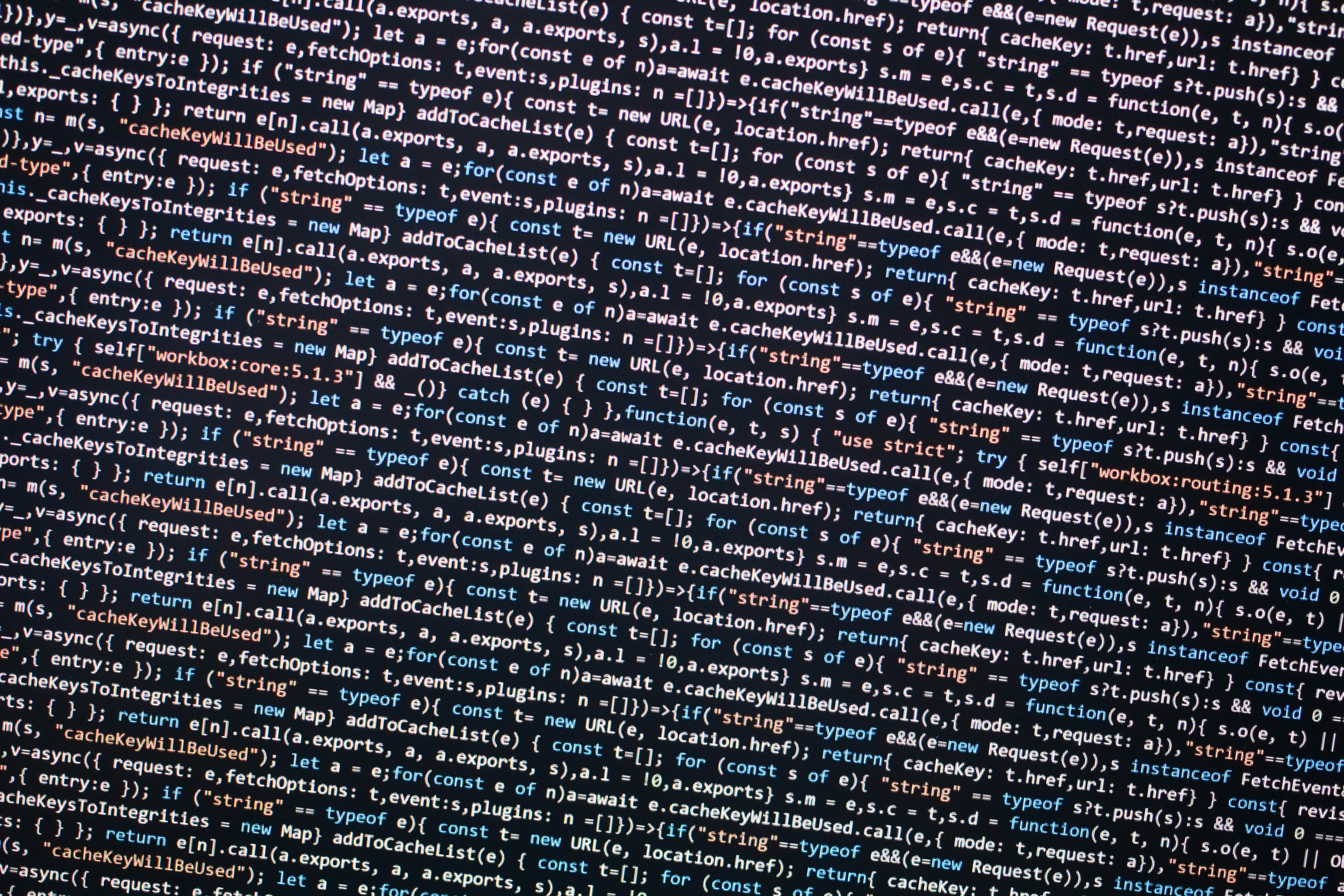 Close up of a developer's hands typing prompts on a laptop surrounded by sticky notes and sketches, AI code suggestions visible on screen