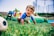 A joyful baby crawling on a colorful mat surrounded by cheerful parents and playful decorations.
