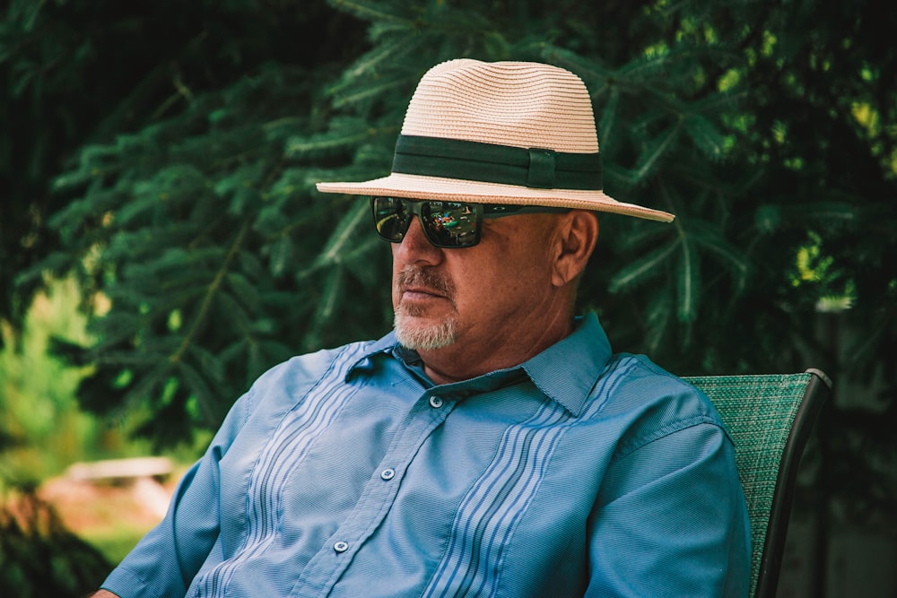 man in blue dress shirt wearing brown fedora hat