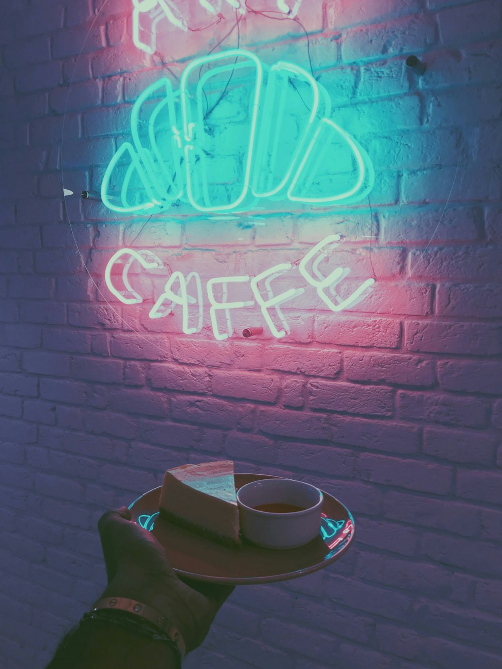 white ceramic teacup on saucer beside red brick wall