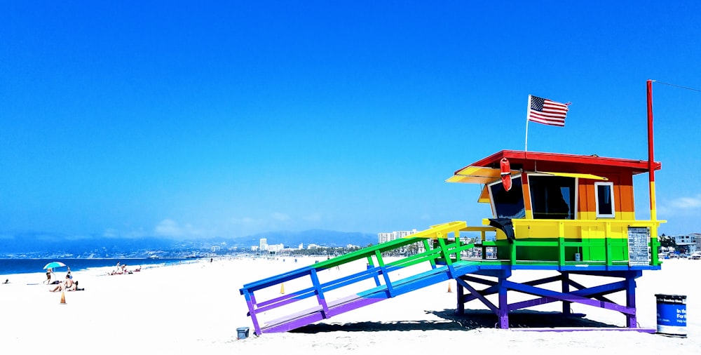 blue and red wooden bench on beach during daytime