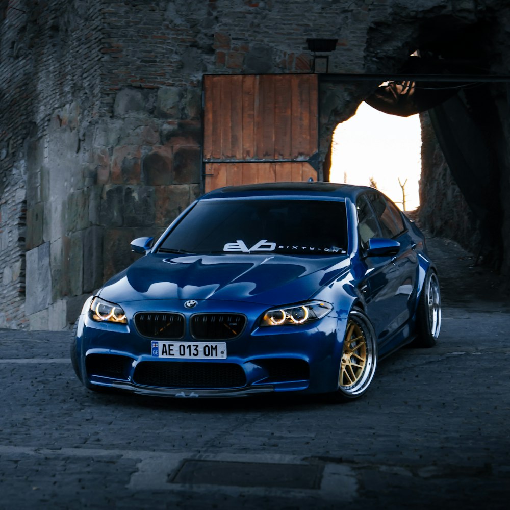 BMW M 3 Coupé blu parcheggiata su un tunnel di cemento grigio durante il giorno