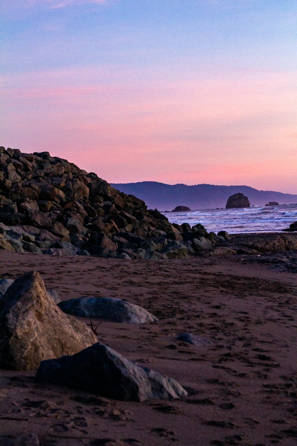 black rock formation on sea shore during daytime