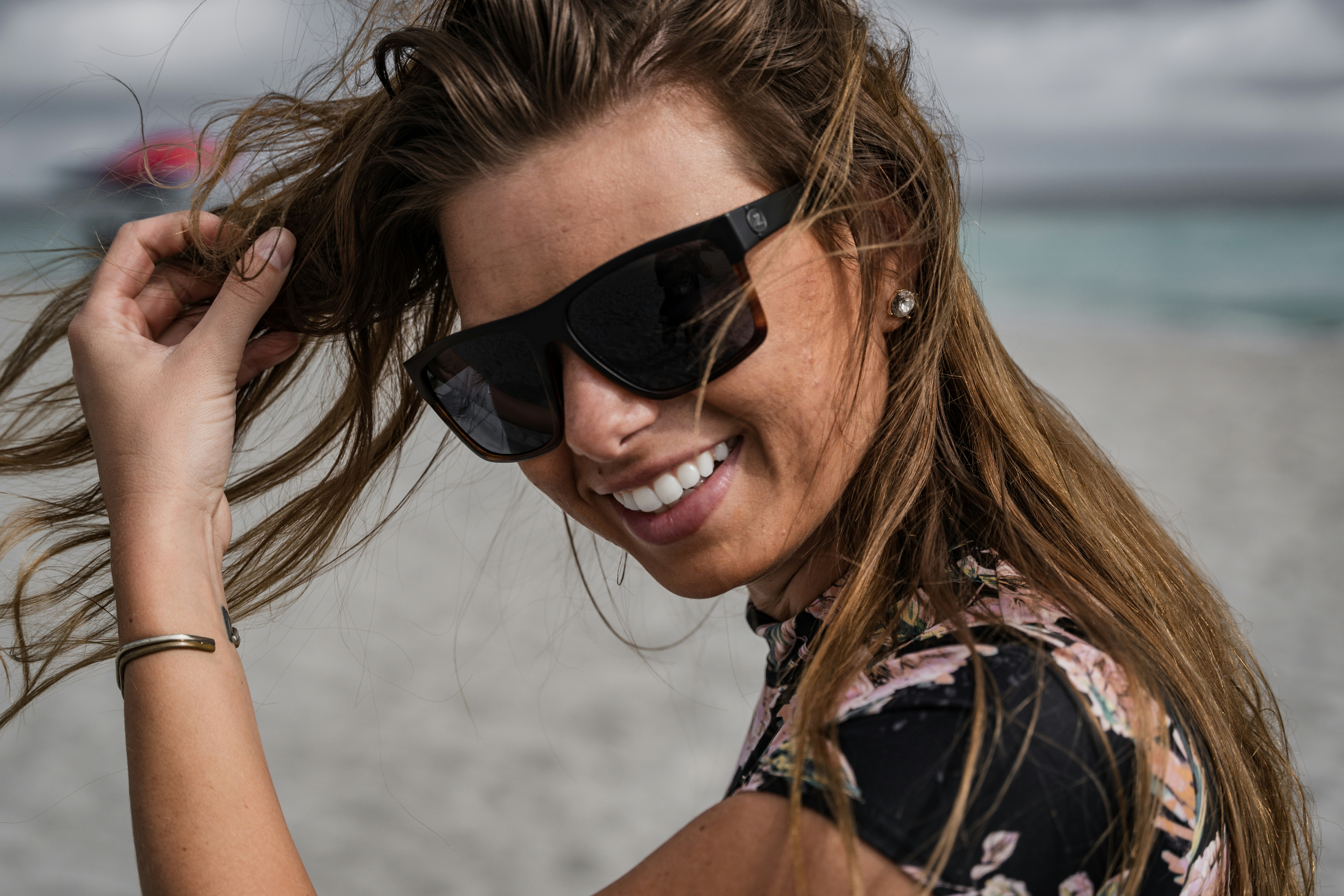 woman in black and pink floral sleeveless top wearing black sunglasses