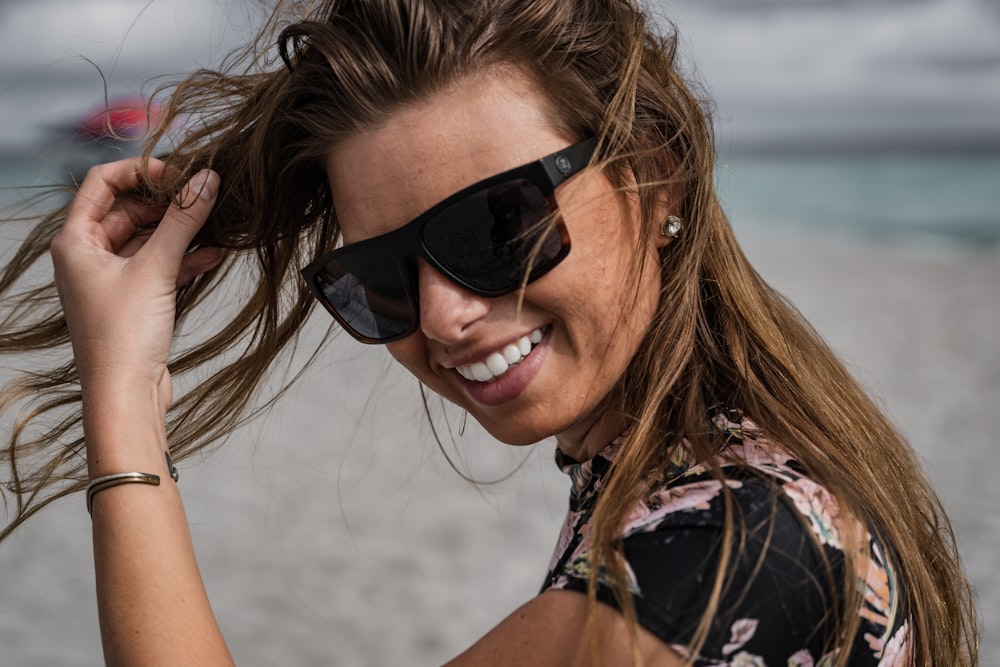 woman in black and pink floral sleeveless top wearing black sunglasses