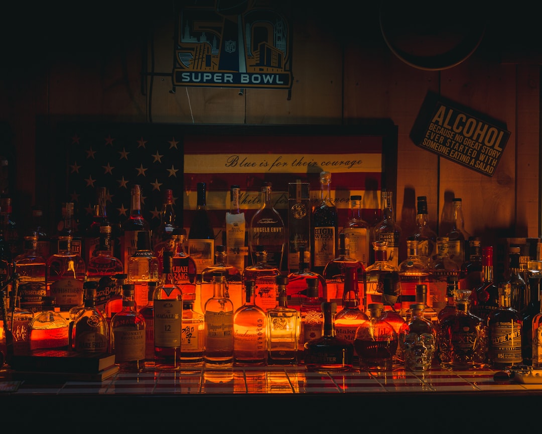 lighted candles on brown wooden table, Home Whiskey Den. Collection of the finest brands of Whiskey and Spirits.