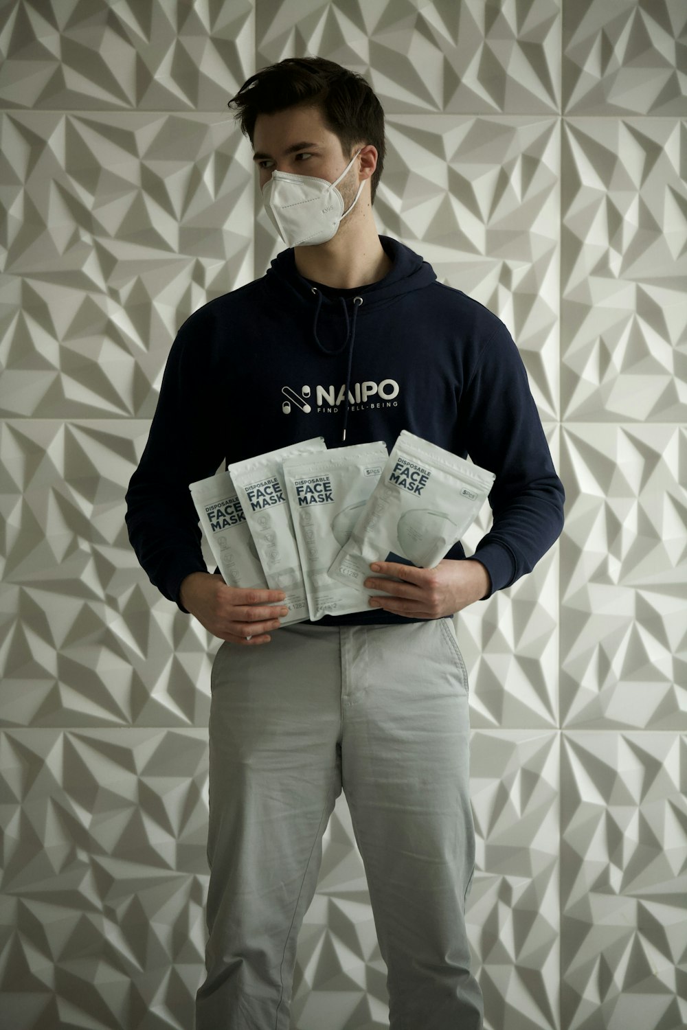 man in black hoodie and gray pants holding white box