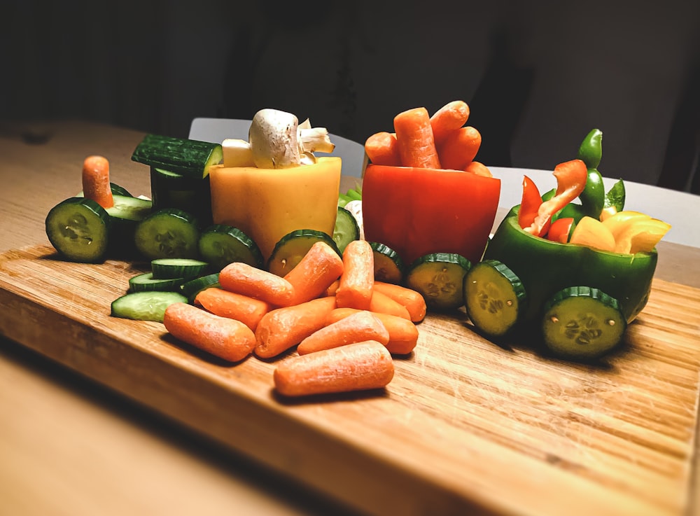 carottes tranchées et poivron vert sur une planche à découper en bois brun