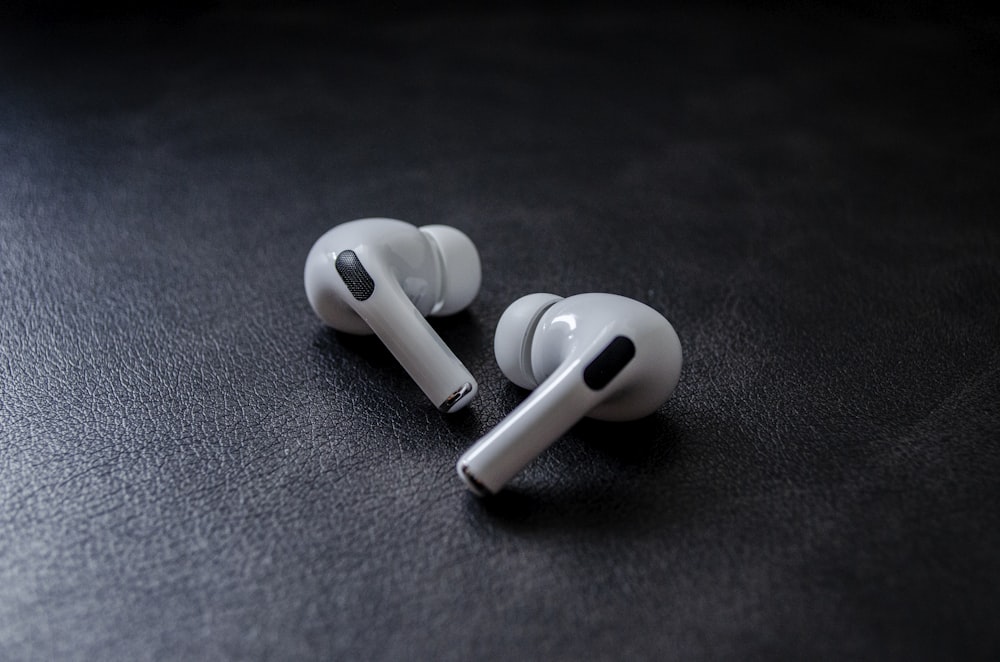 white earbuds on black textile