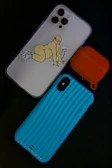 Colorful stickers and phone cases laid out on a dark background with neon accents.