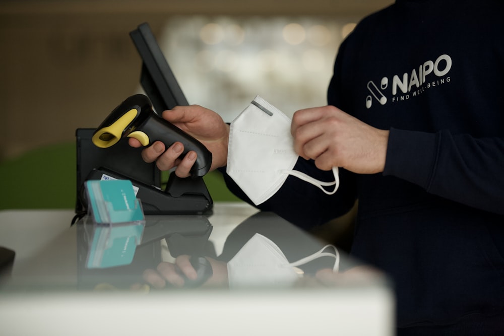 Person in schwarzem Langarmhemd mit schwarzem Tablet-Computer