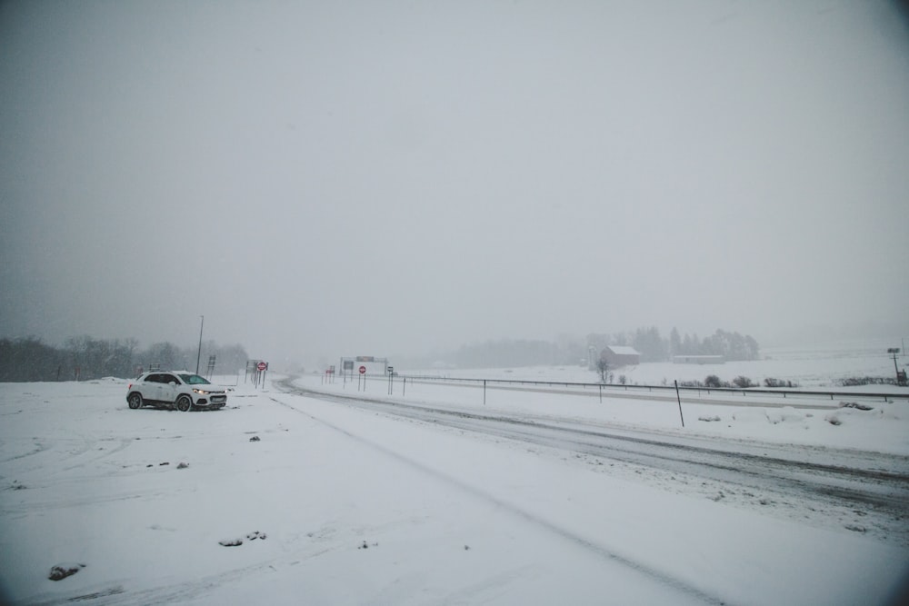 white car on snow covered road during daytime