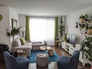 A modern living room digitally staged with bright furniture and plants.