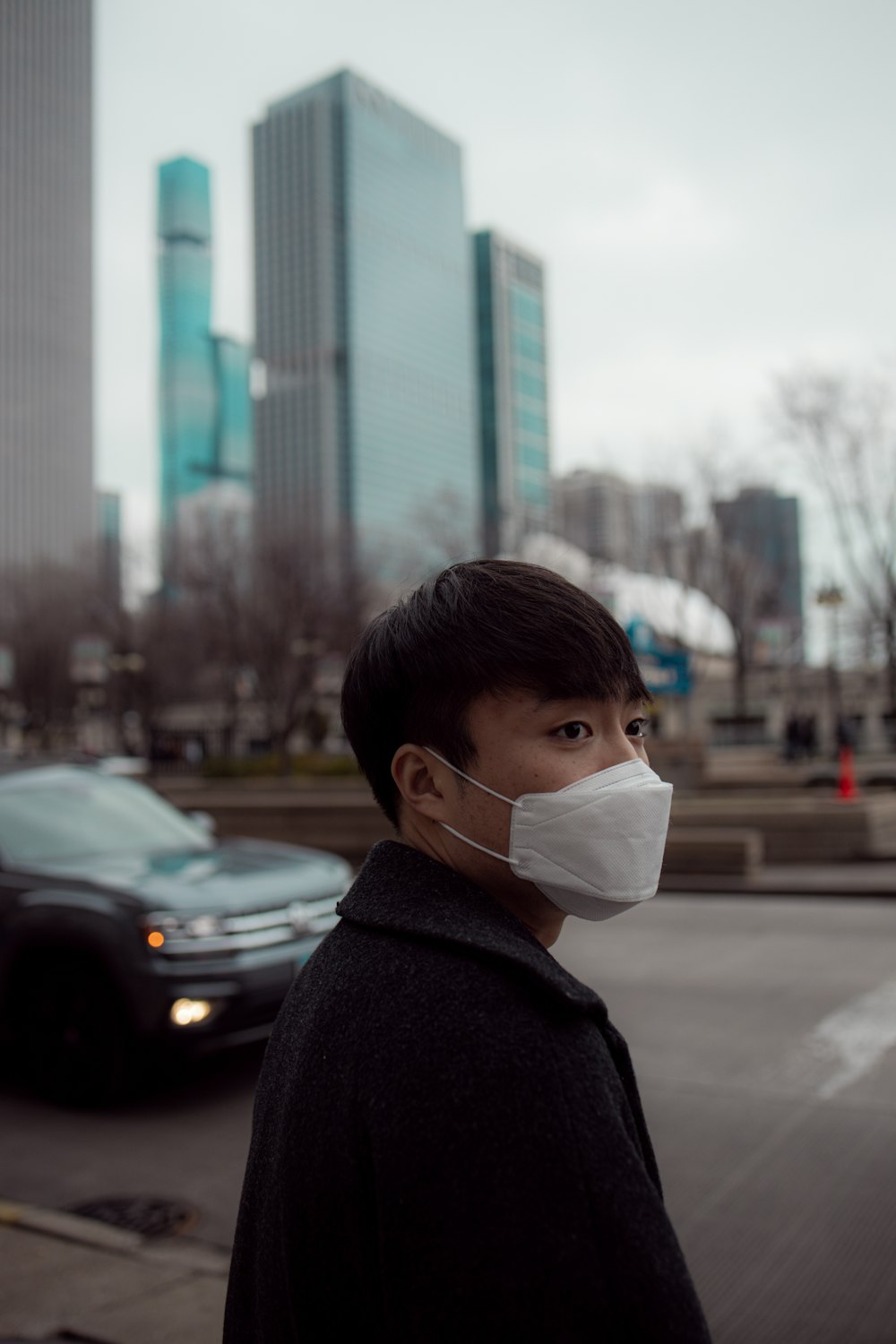 man in gray hoodie wearing white face mask