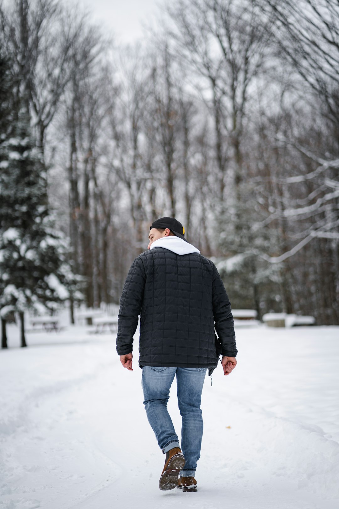 man in black jacket standing on snow covered ground during daytime