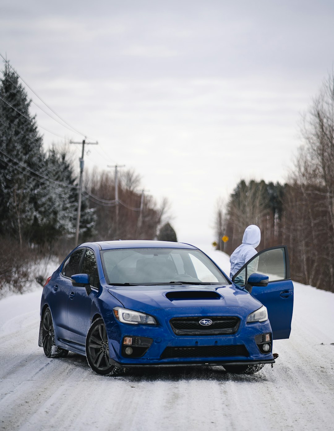 blue bmw m 3 coupe on snow covered road during daytime