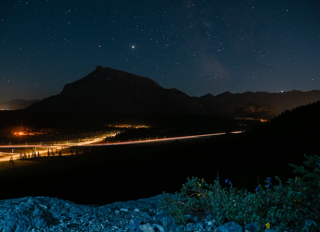 body of water near mountain during night time