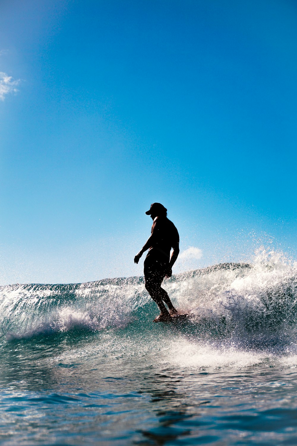 Mann in schwarzer Jacke und Hose beim Surfen auf Meereswellen tagsüber