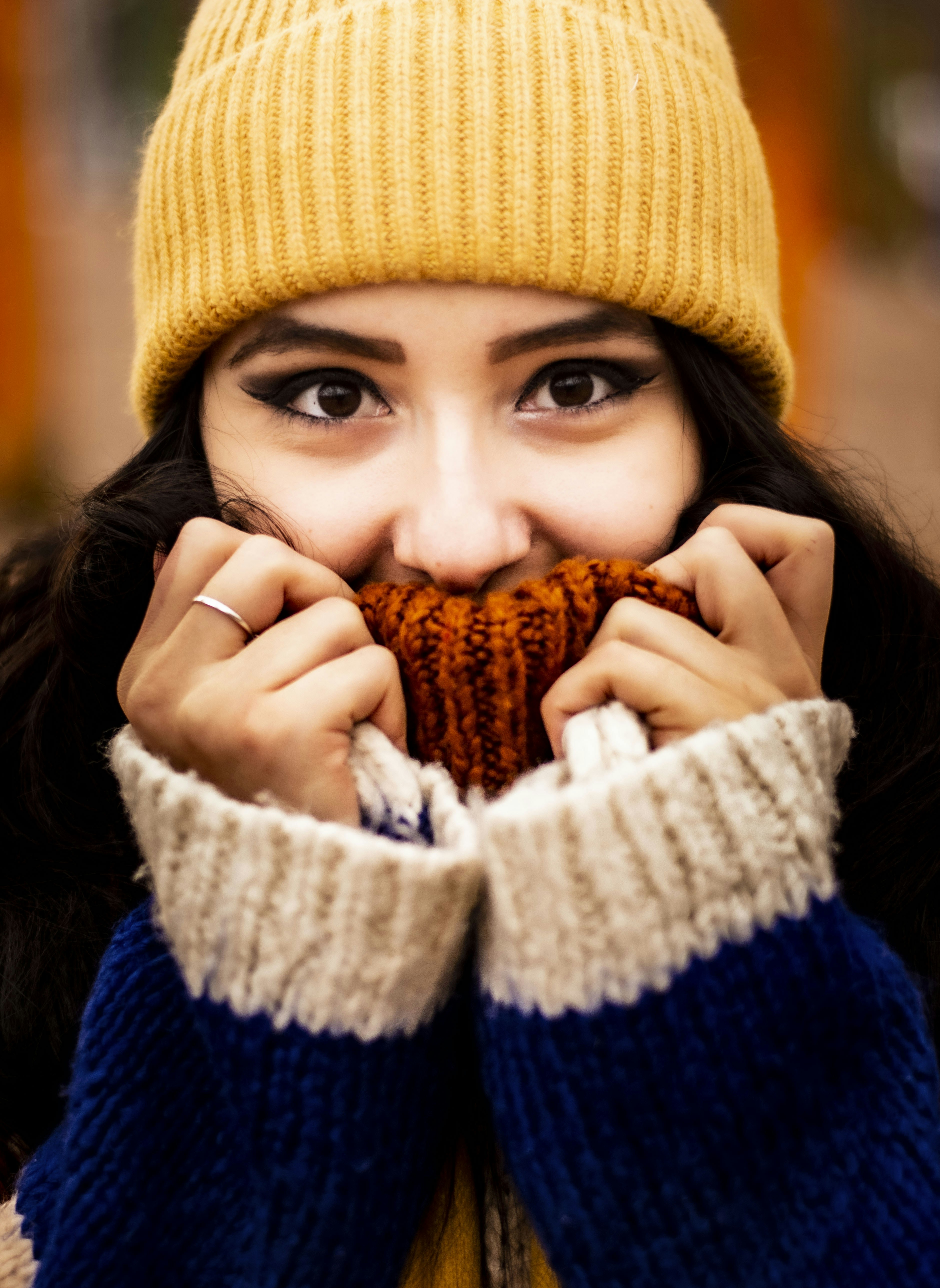 Femme en bonnet en tricot marron couvrant son visage avec sa main