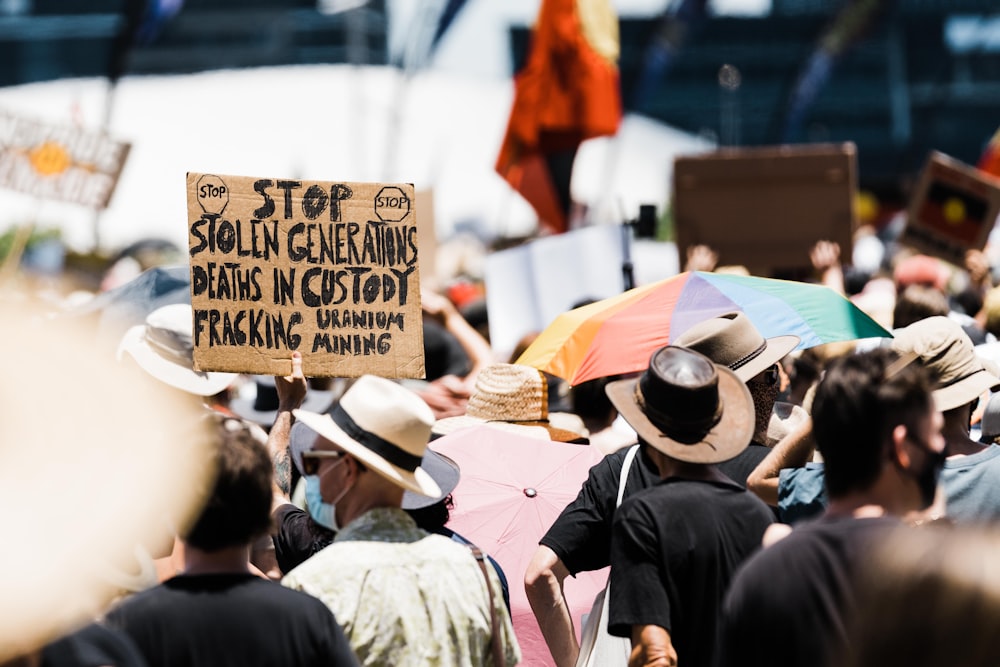 people in black and brown hat standing on street during daytime