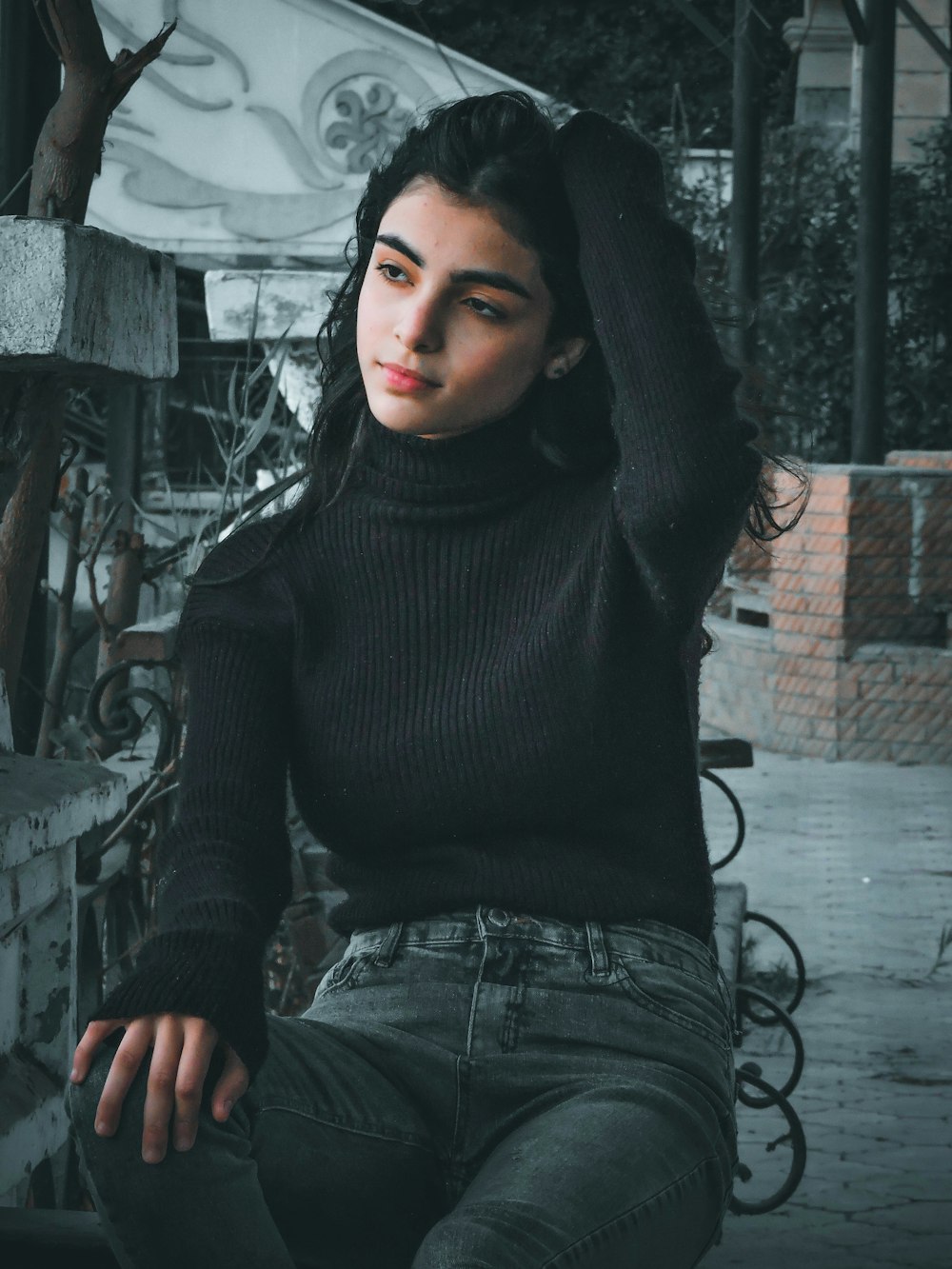 woman in black turtleneck sweater and blue denim jeans sitting on black  metal fence photo – Free Grey Image on Unsplash