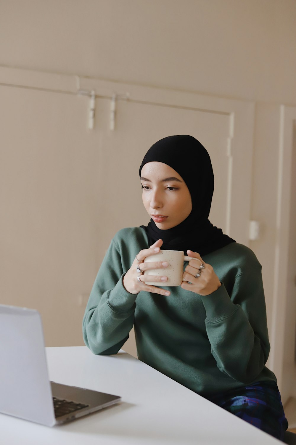 woman in green long sleeve shirt and black hijab