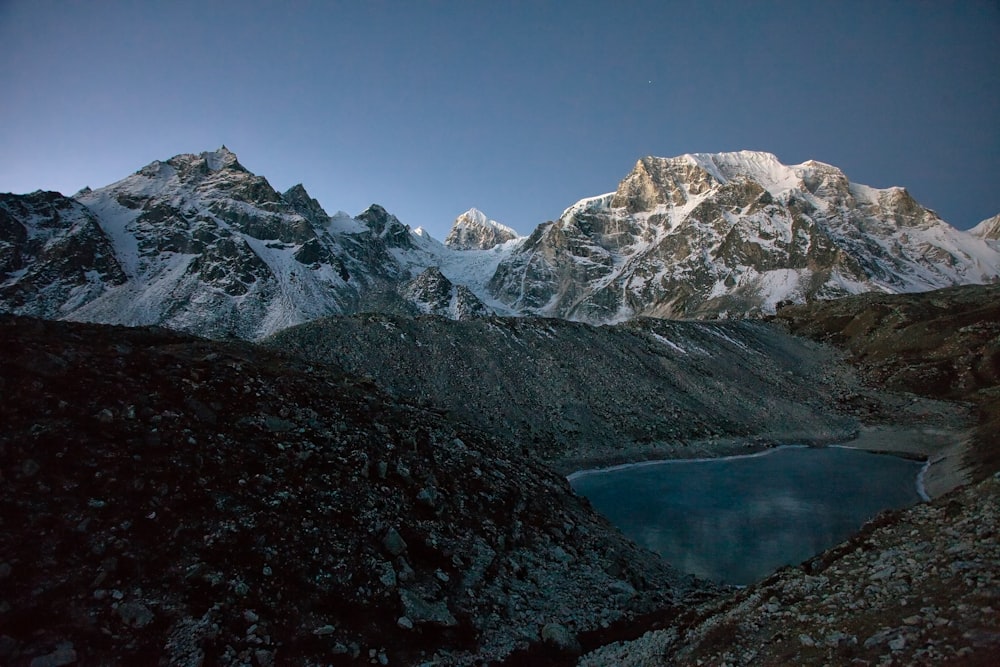 snow covered mountain near lake during daytime