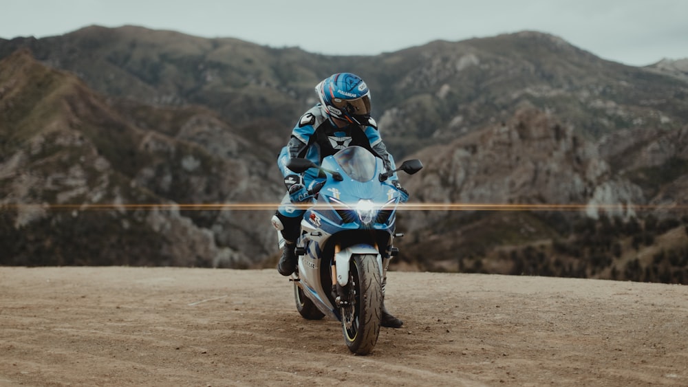 man in blue and white jacket riding on white and black dirt bike during daytime