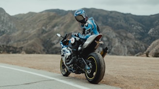 man in blue and white jacket riding black motorcycle on road during daytime