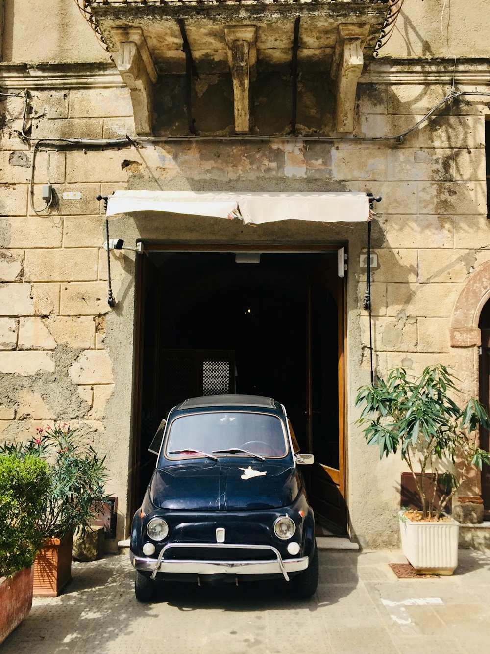 blue volkswagen golf parked beside brown brick wall