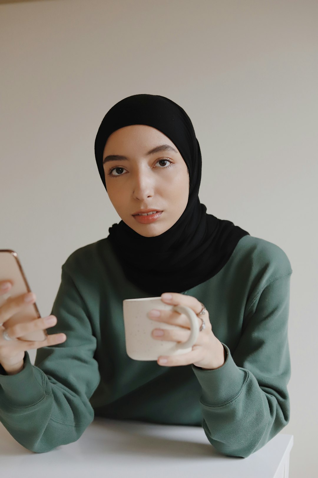 woman in black hijab holding iphone