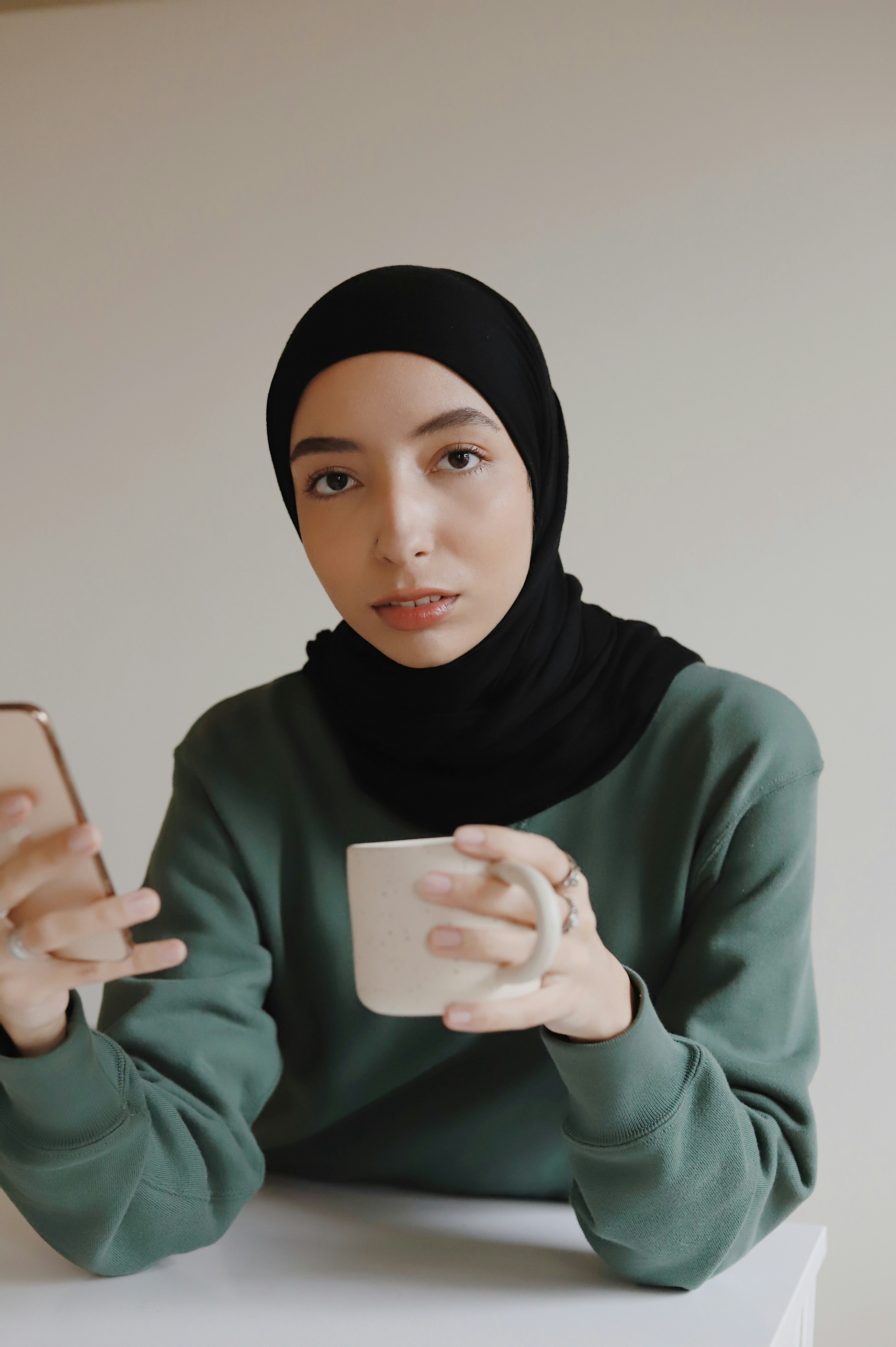 woman in black hijab holding iphone