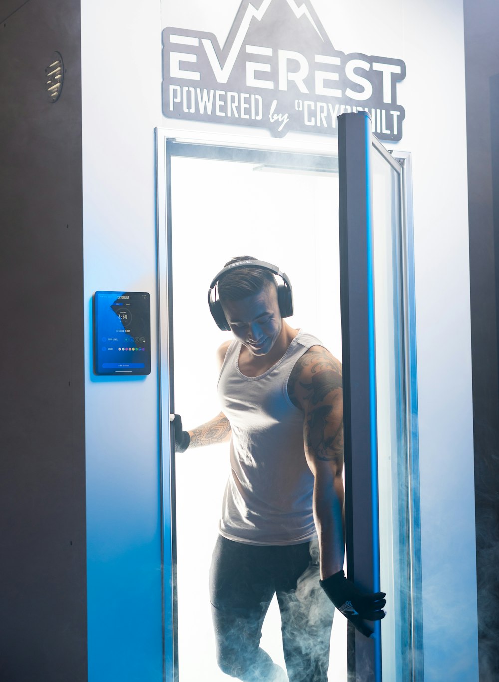 파란색 문 옆에 서 있는 흰색 고글을 쓴 흰색 긴팔 셔츠를 입은 남자