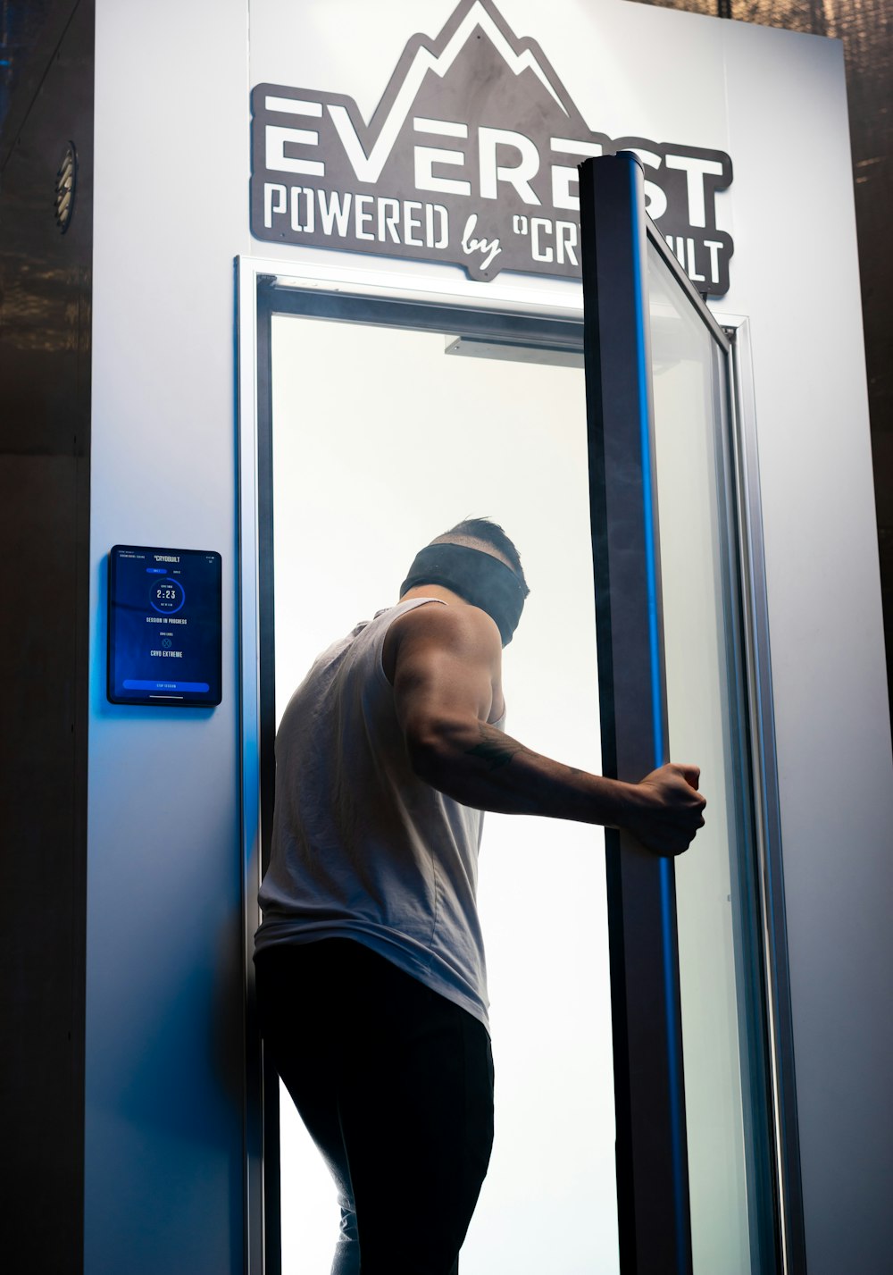 man in gray crew neck t-shirt and black pants standing beside blue door