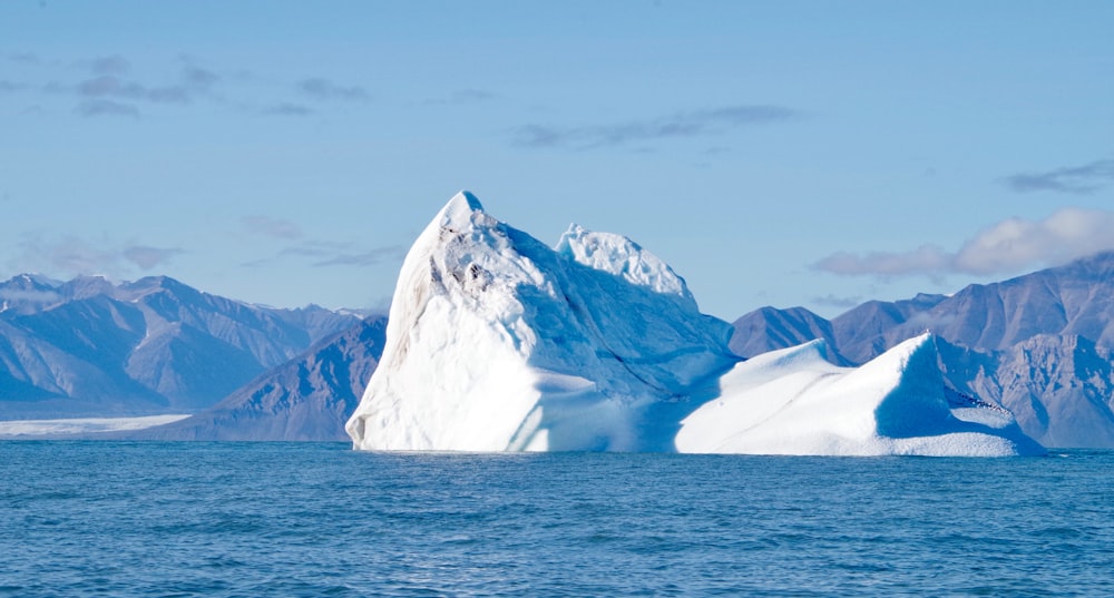 snow covered mountain near body of water during daytime