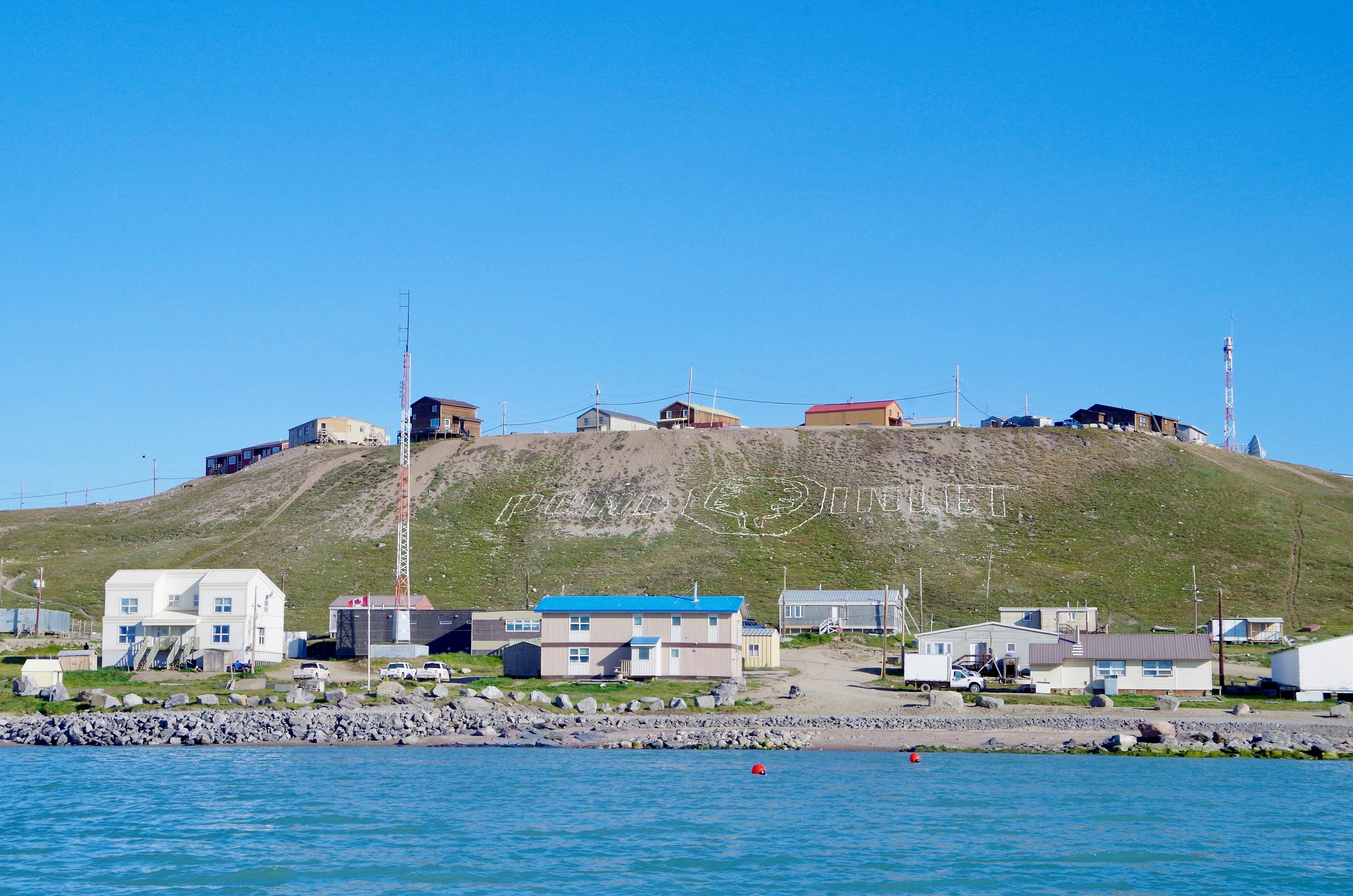 houses near body of water during daytime, Hamlet of Pond Inlet on Baffin Island