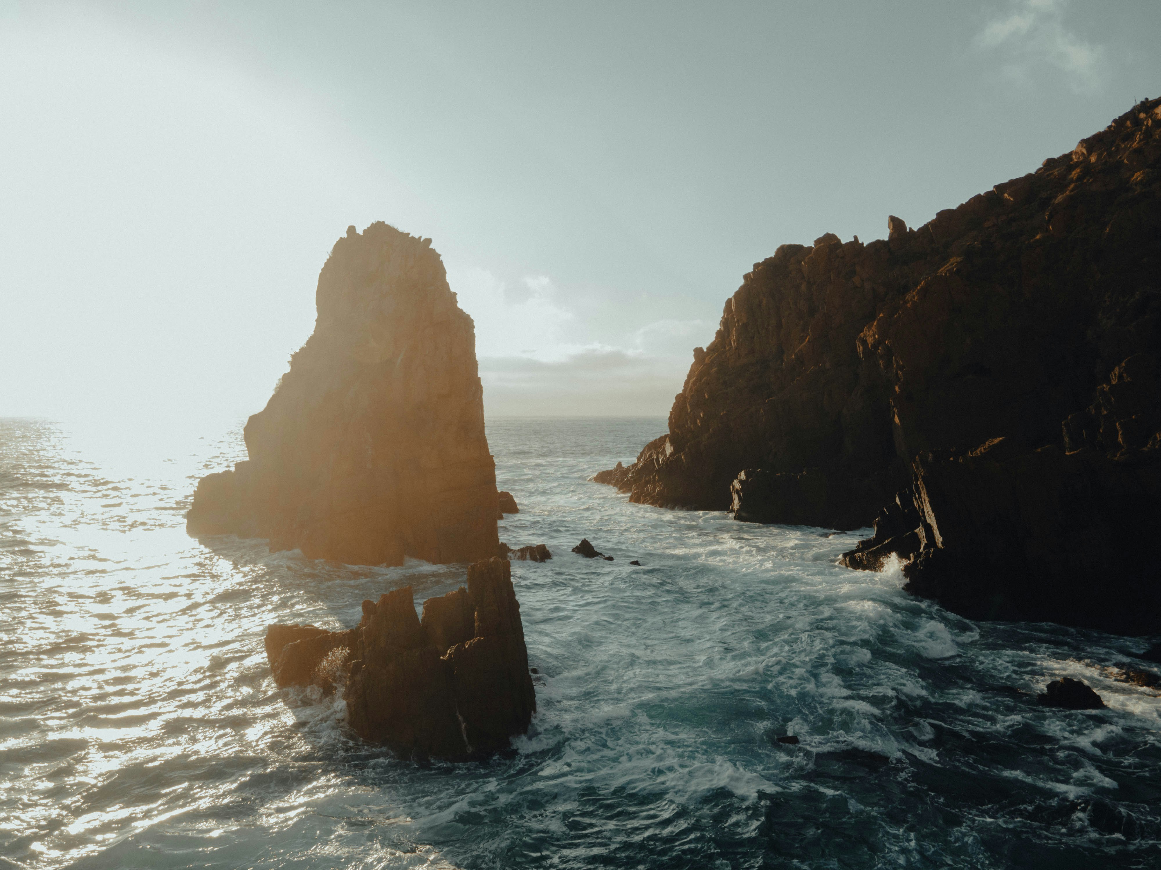 brown rock formation on sea during daytime