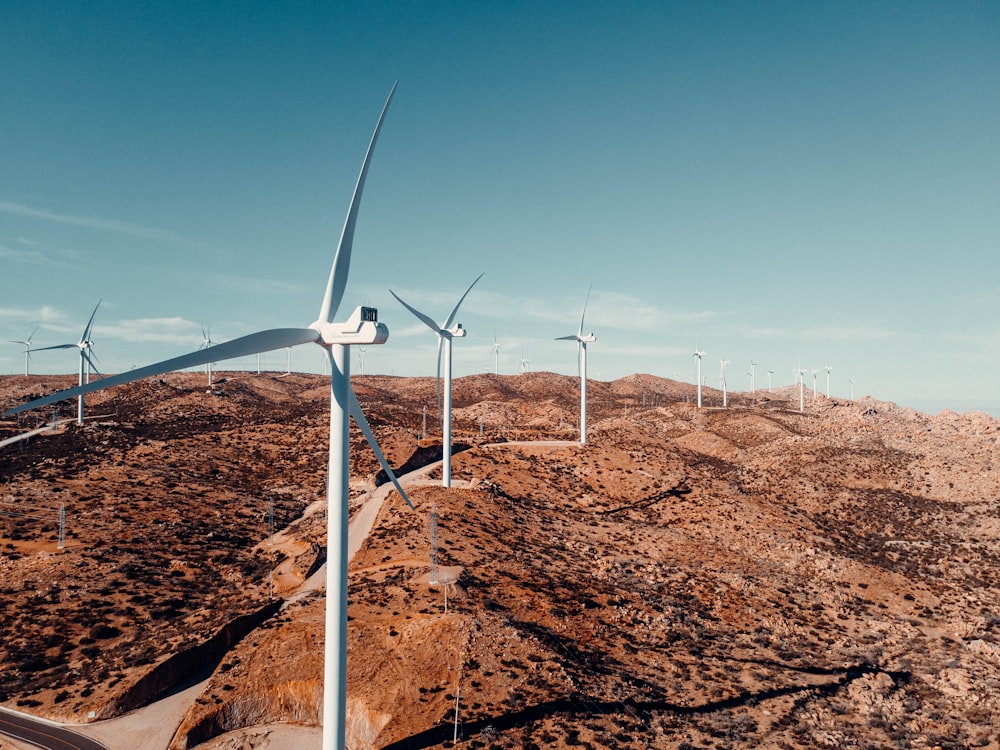 turbina eólica blanca en campo marrón bajo cielo azul durante el día