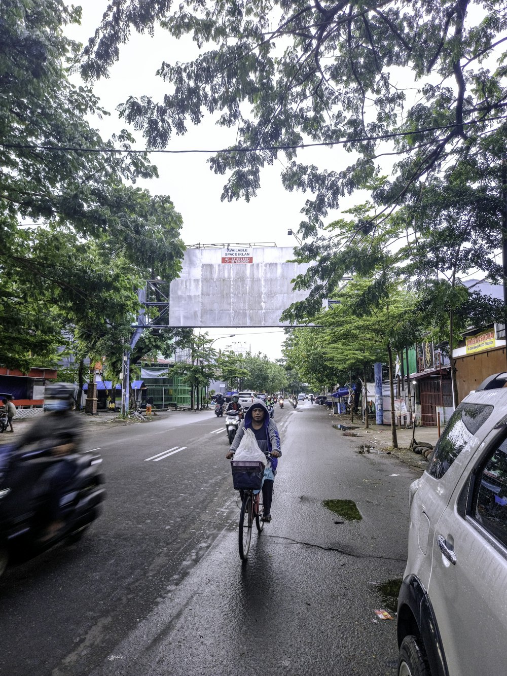 Frau in blauer Jacke fährt tagsüber Fahrrad auf der Straße