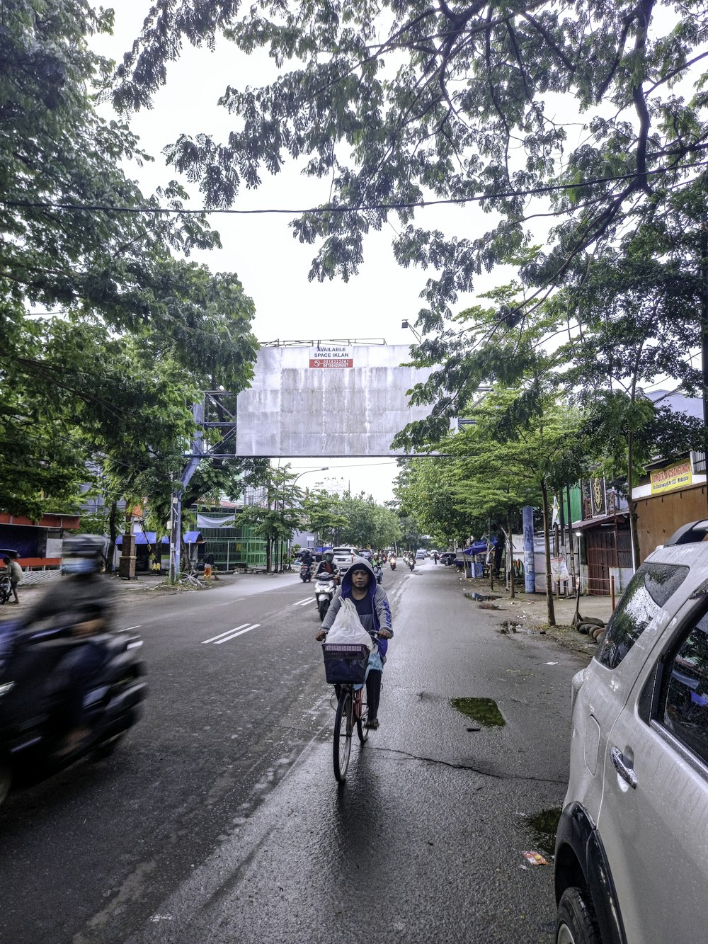 woman in blue jacket riding bicycle on road during daytime