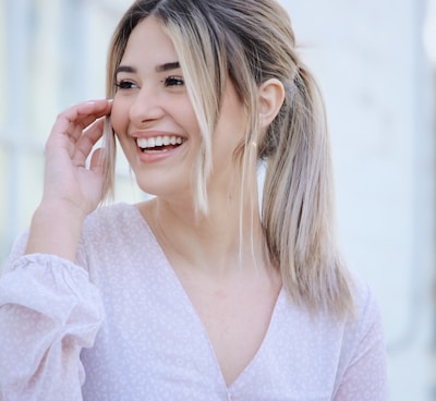 woman in white v neck long sleeve shirt smiling