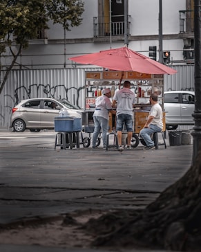 man in blue denim jeans sitting on gray metal bench near white car during daytime