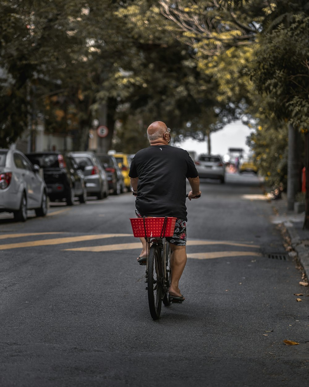 homem na camisa preta que anda de bicicleta na estrada durante o dia