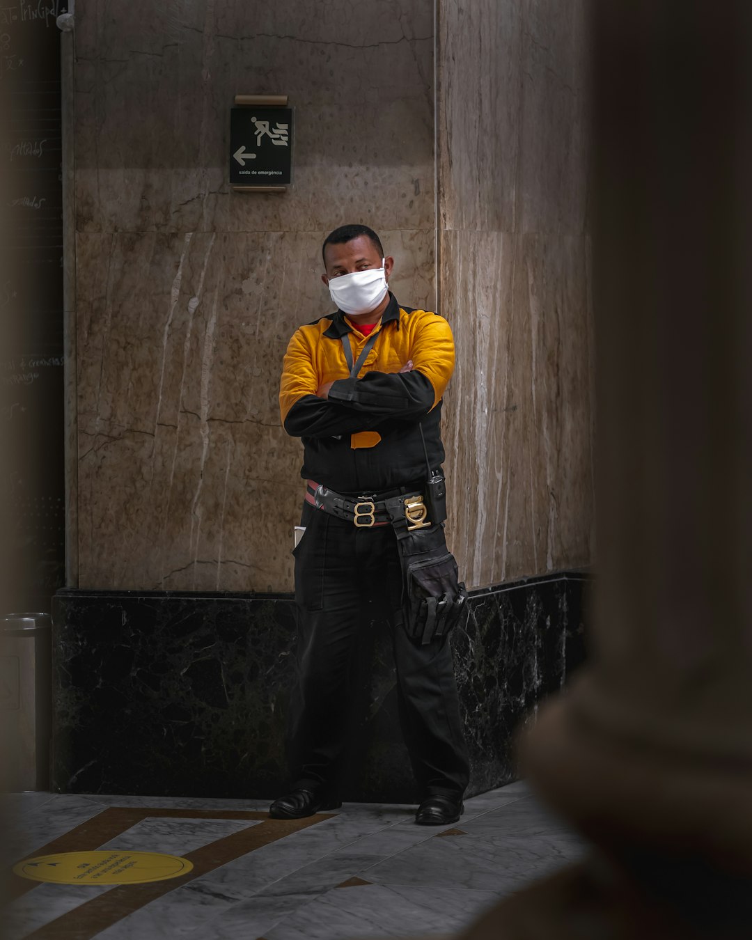 man in yellow jacket and black pants wearing white mask