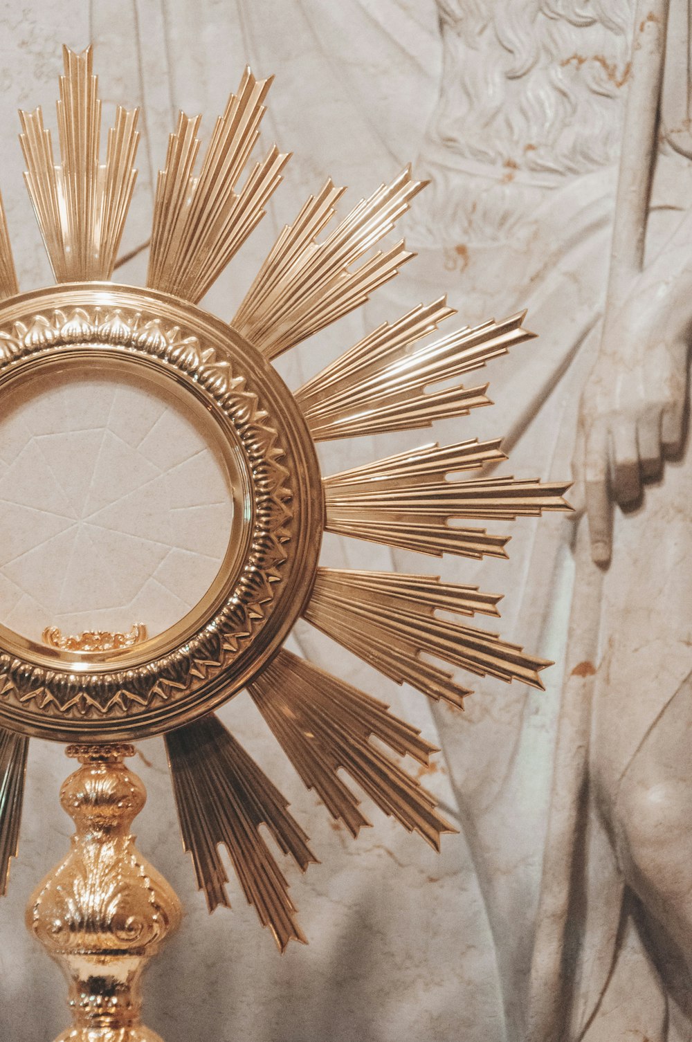 gold round framed mirror on white textile