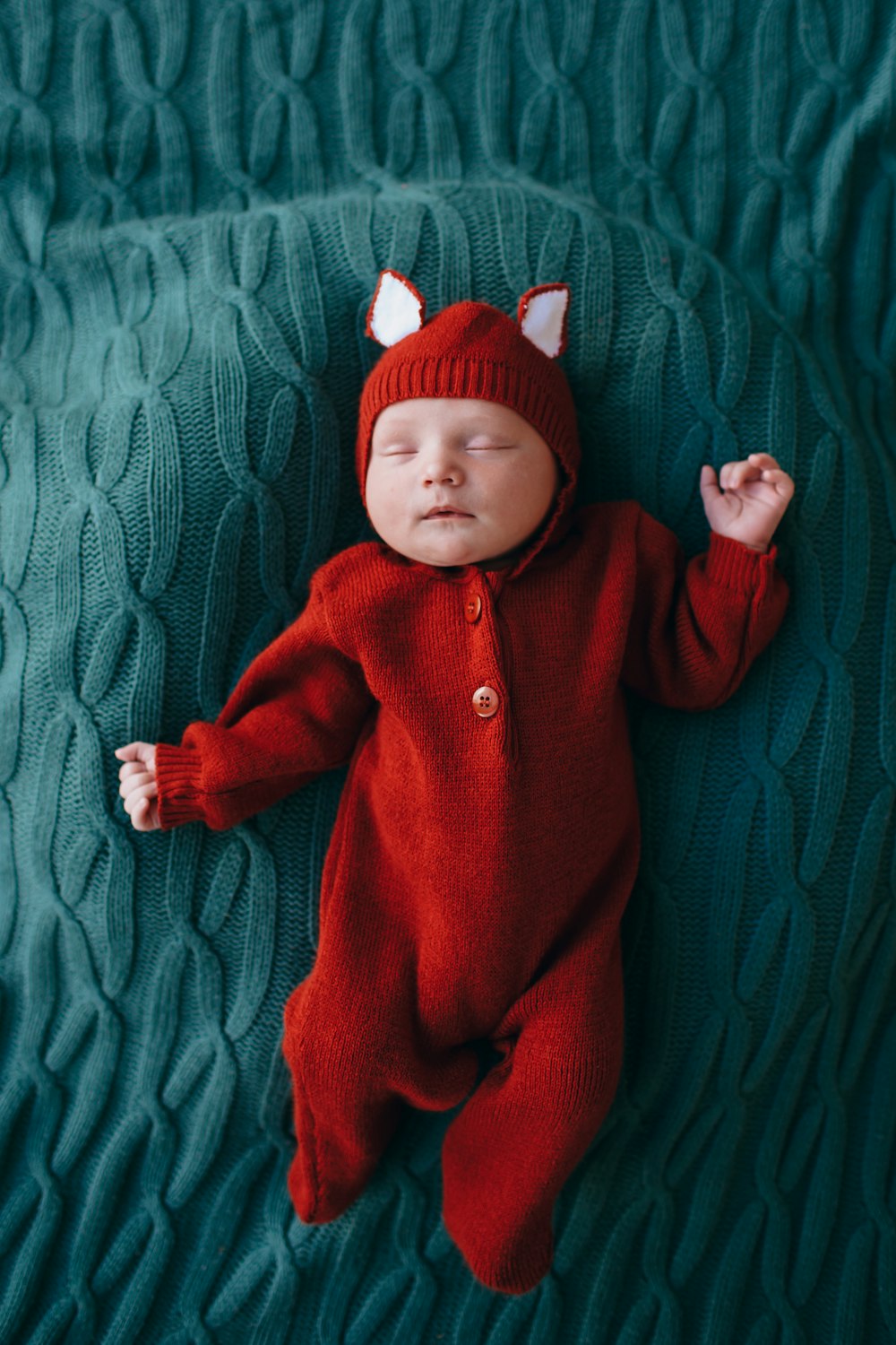 baby in red knit cap and red jacket