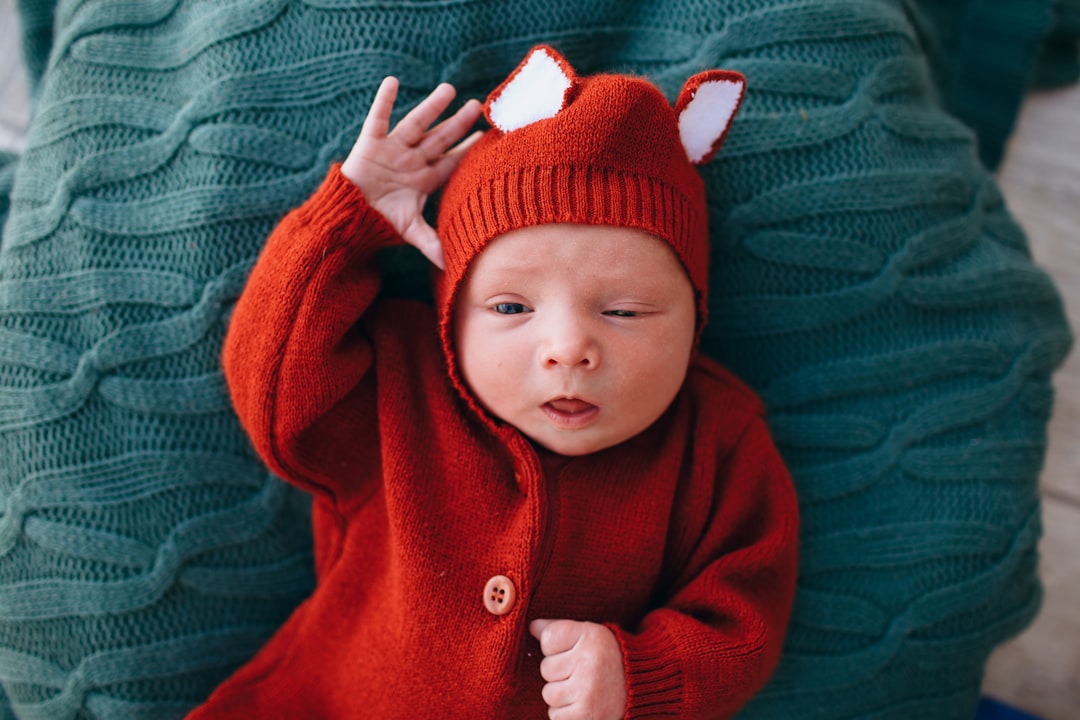 baby in red knit cap and red jacket