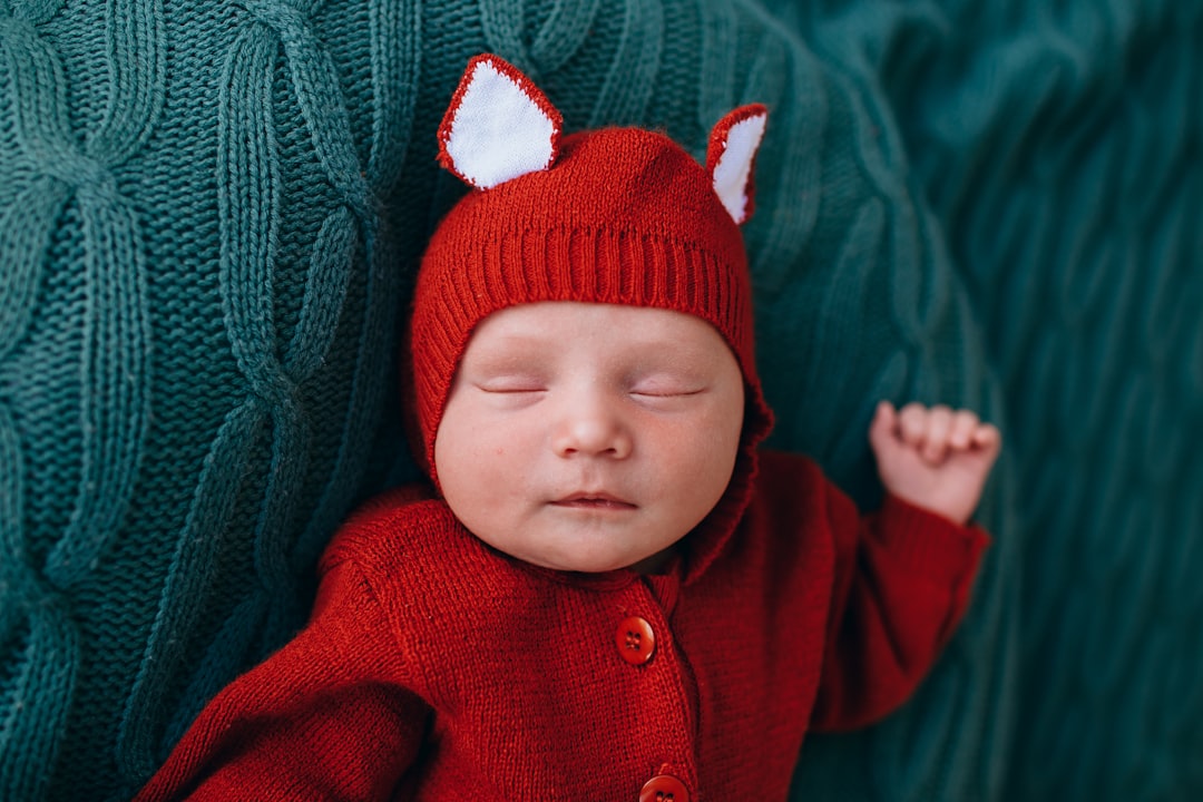 baby in red knit cap and red sweater